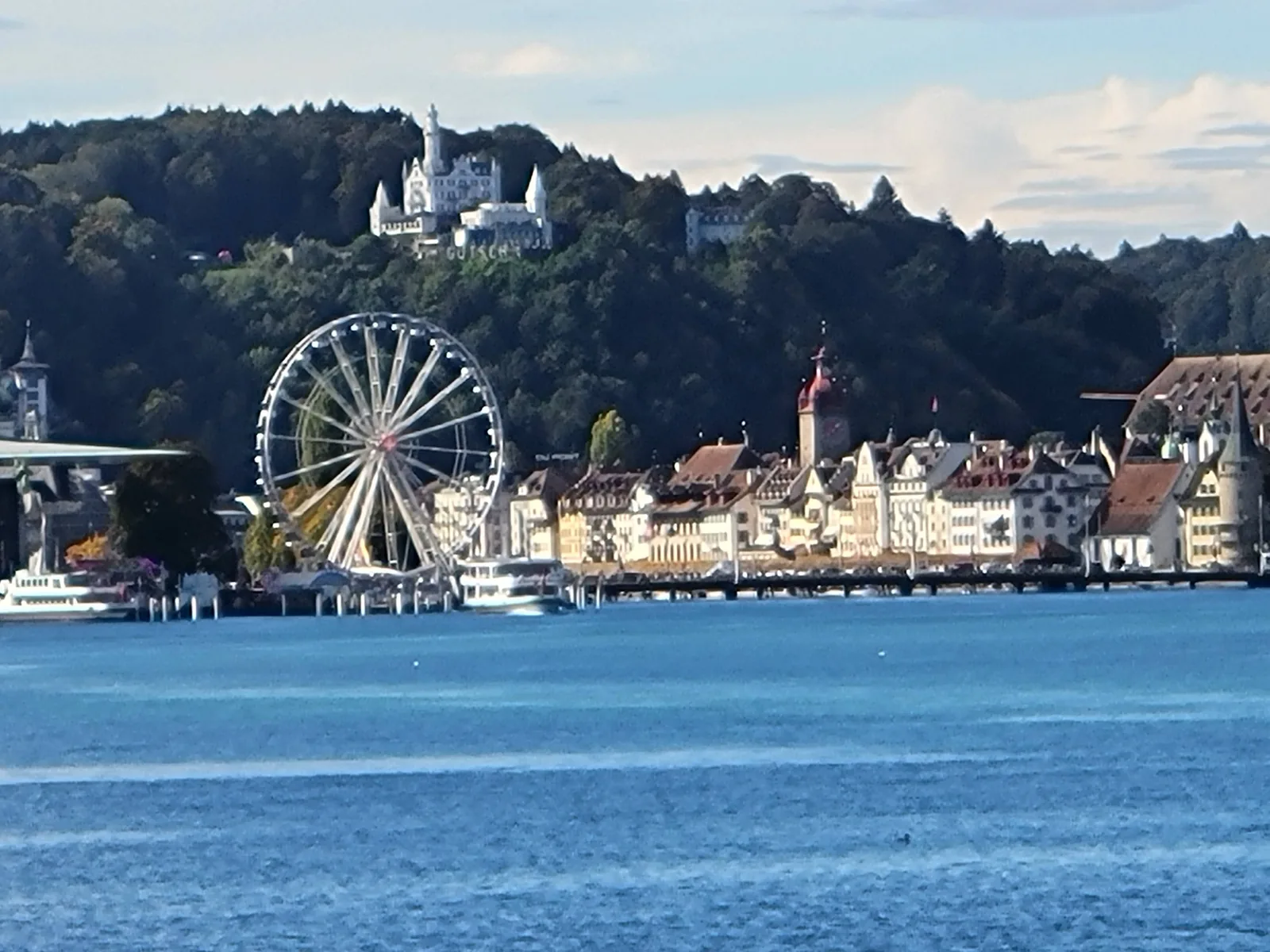 Lakeside town with a ferris wheel at dusk