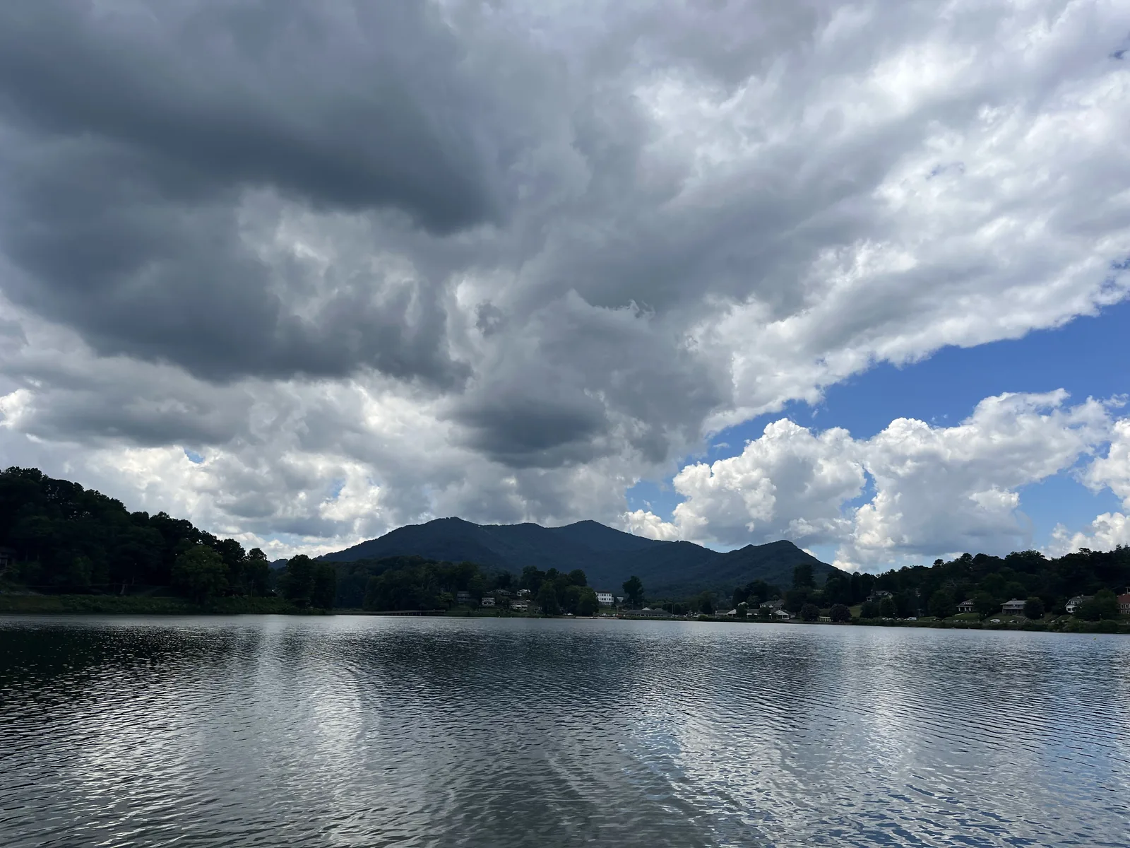 Dark lake water under towering summer clouds