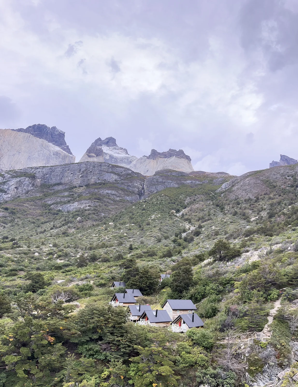 Hiker in a magenta jacket above a glacier lake