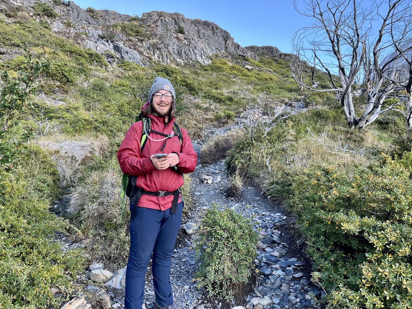 Hiker smiling on a rocky alpine trail