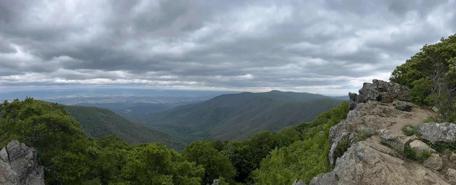 Wide mountain valley under streaked clouds