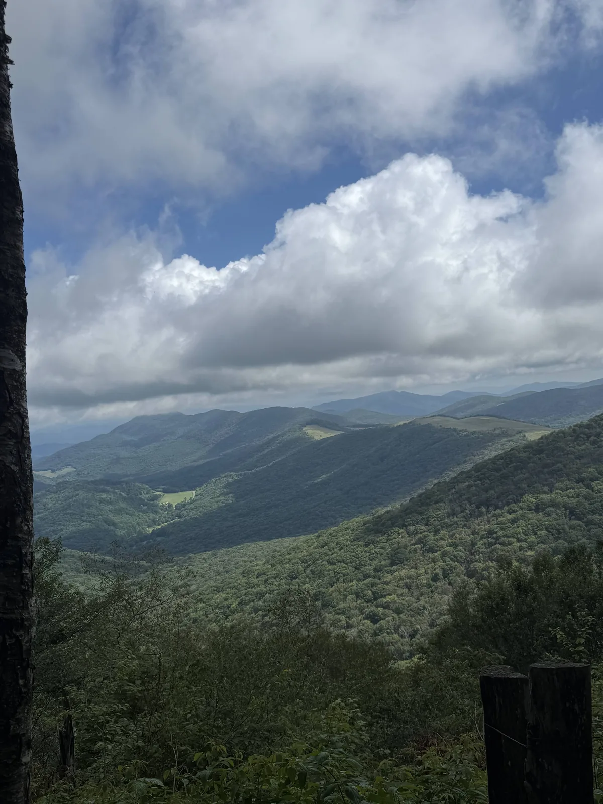 Sunlit mountain valley beneath towering clouds