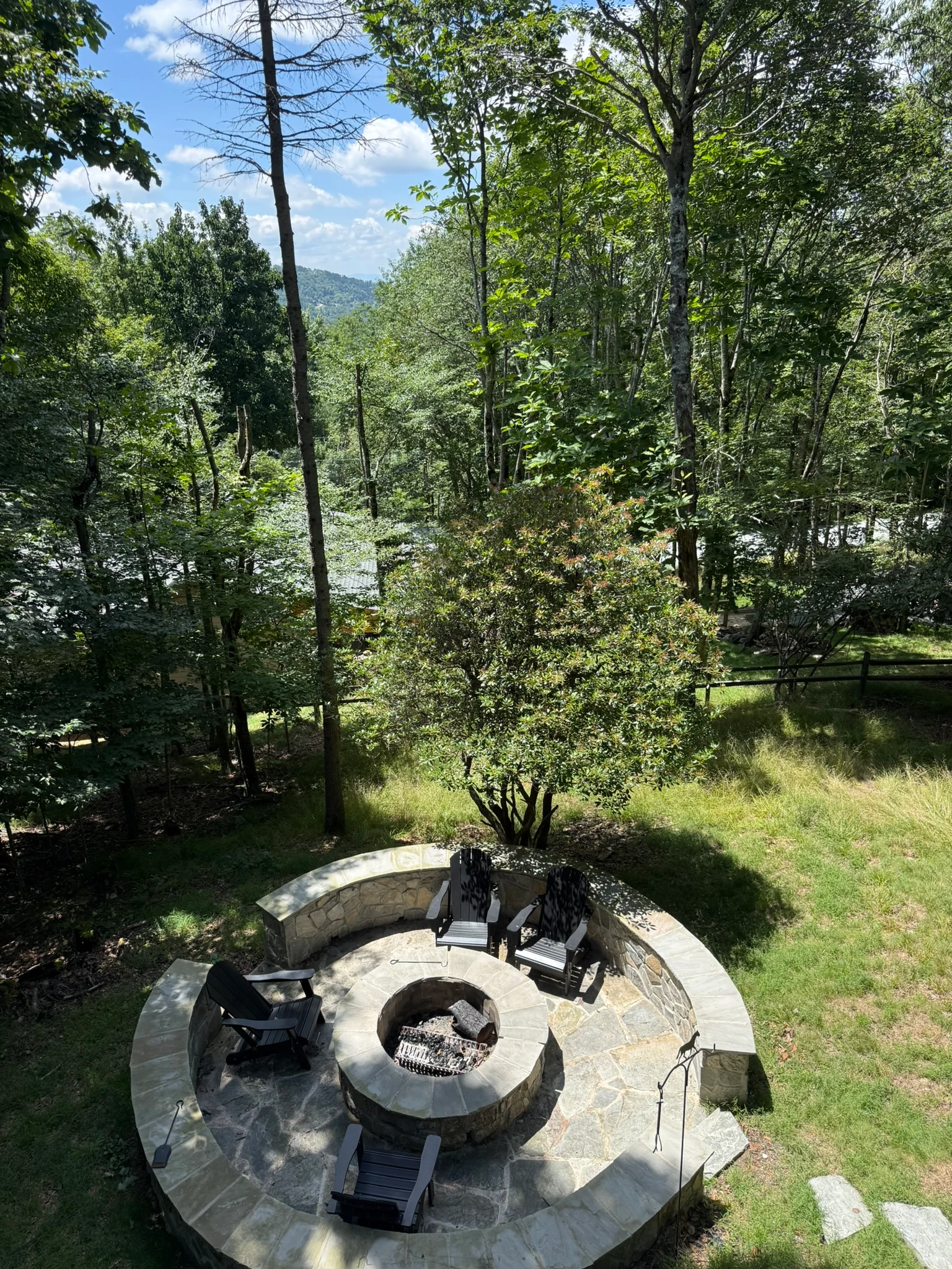 The cabin firepit set among trees above the mountain road.