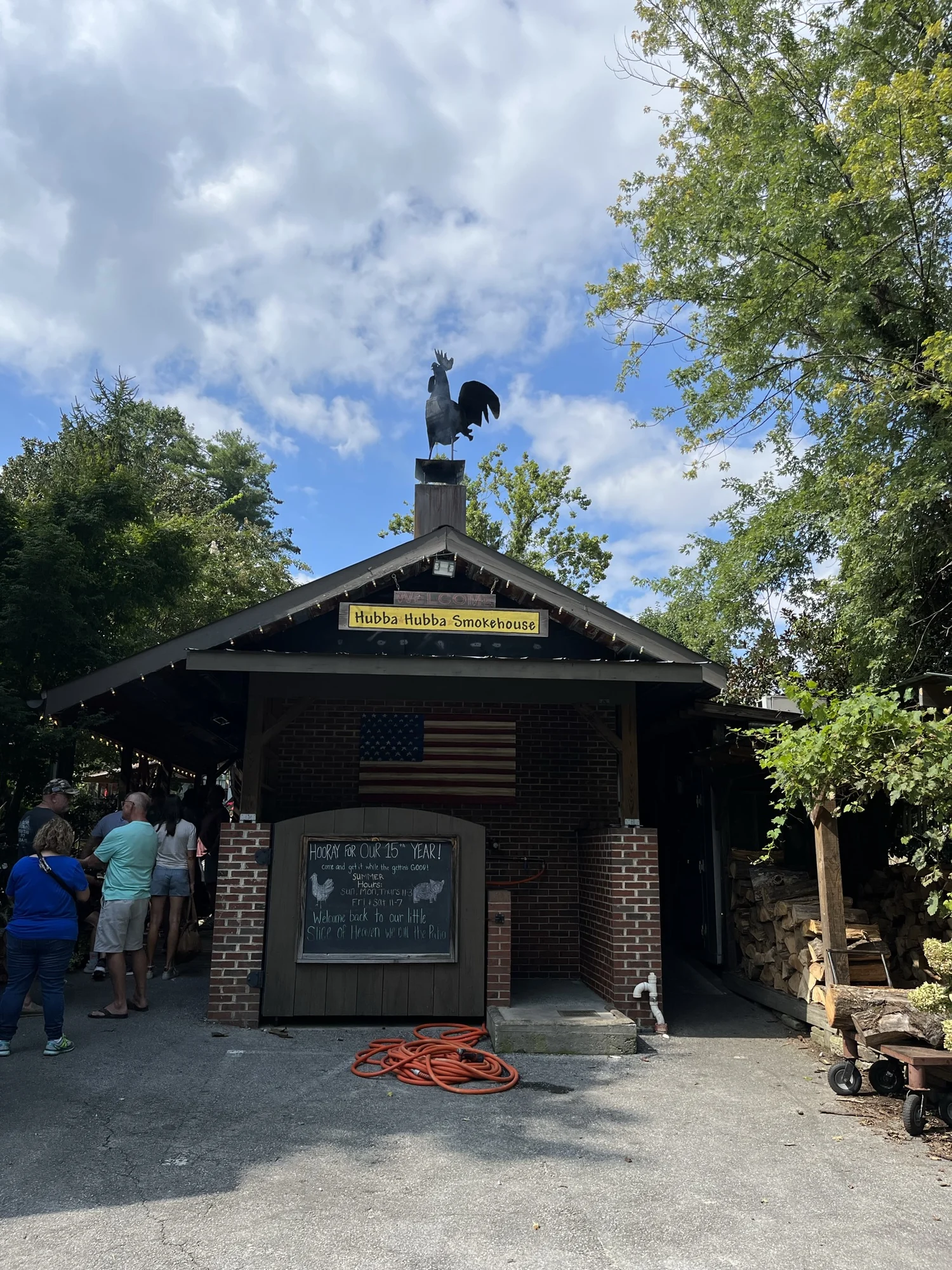 The entrance to Hubba Hubba Smokehouse beneath a large rooster sculpture.