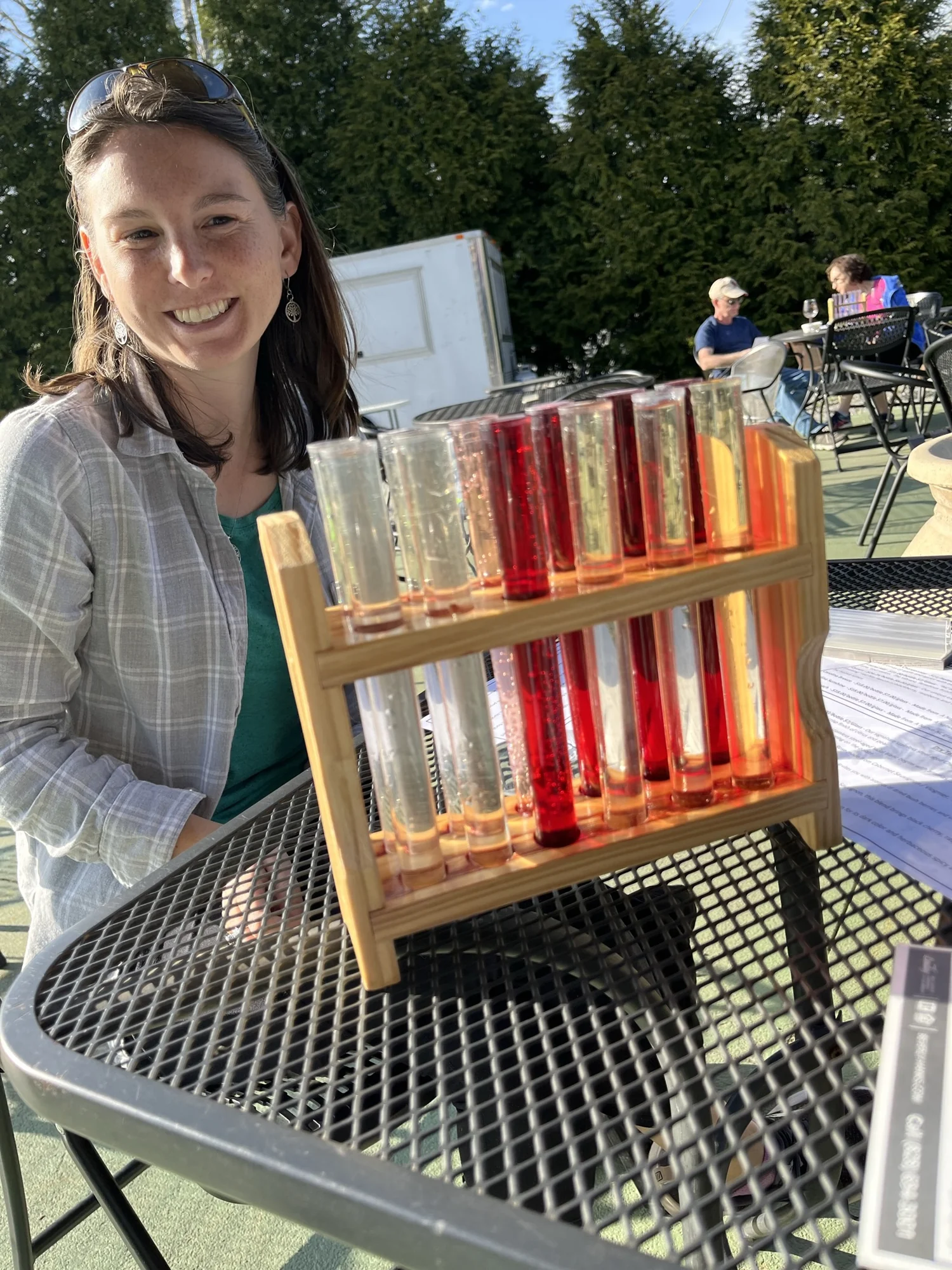 Sydney smiling behind a rack of colorful tasting tubes.