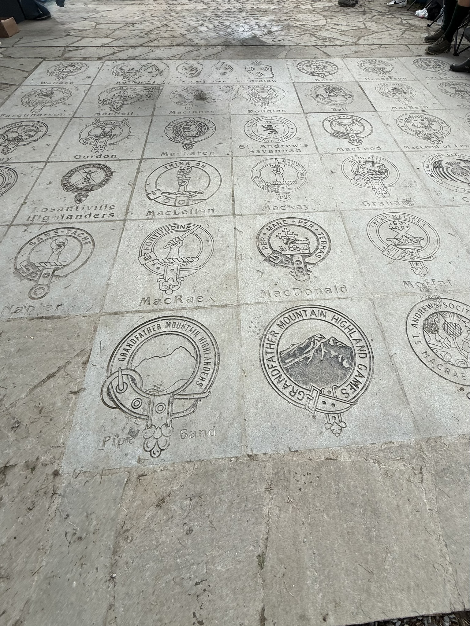 Engraved Scottish clan emblems arranged across the Grandfather Mountain Highland Games grounds.