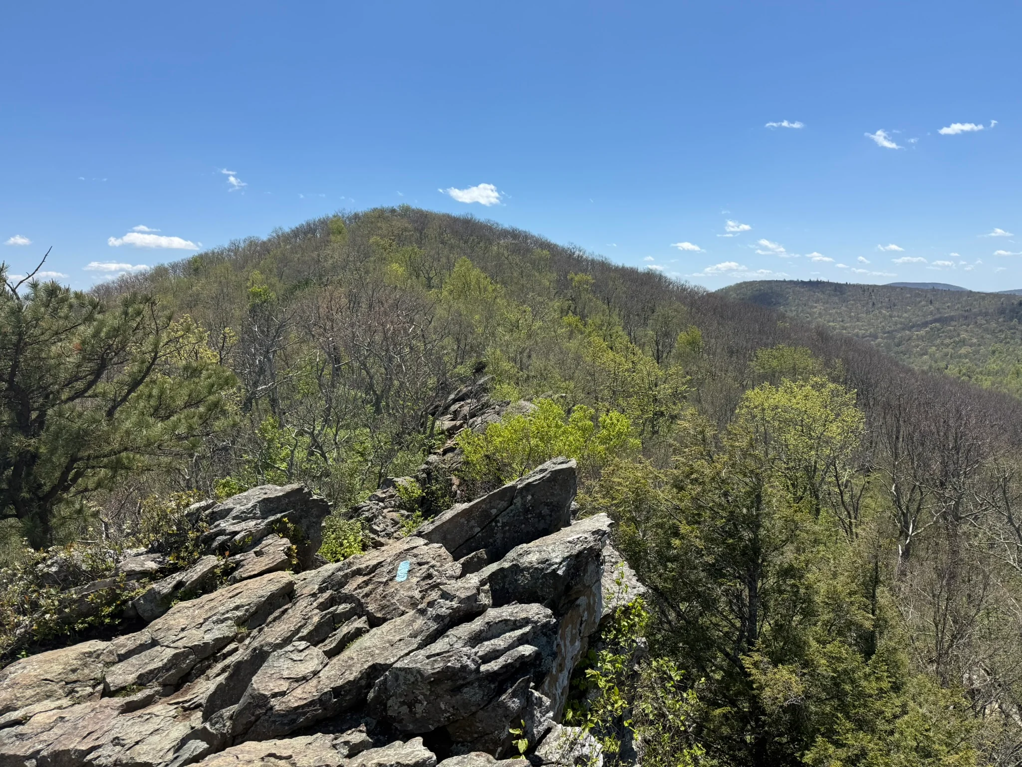 Rocky Bearfence Mountain terrain with a person on an overlook above Shenandoah ridges.