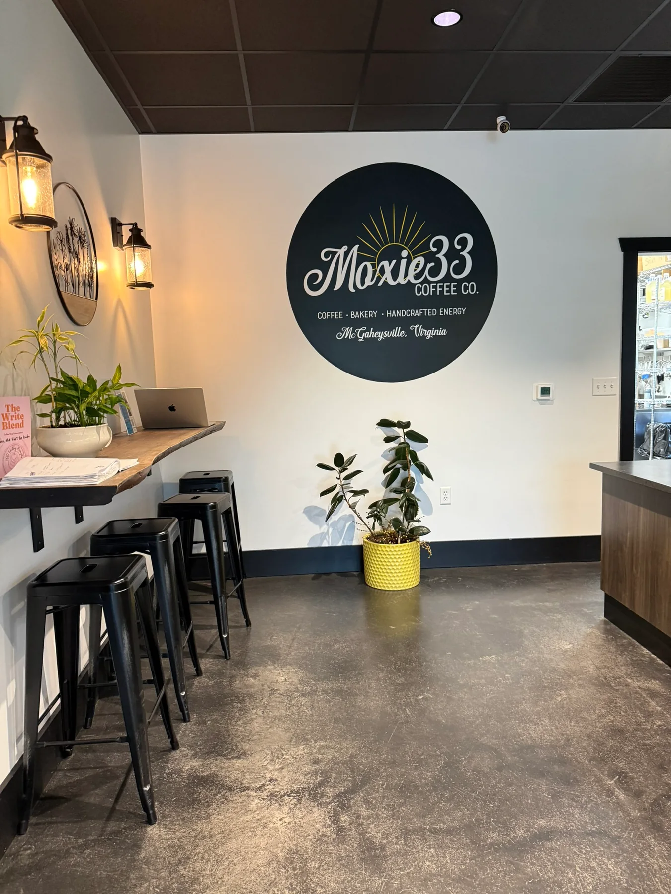 The interior of Moxie 33 Coffee Co. in McGaheysville with its round wall logo and coffee counter.