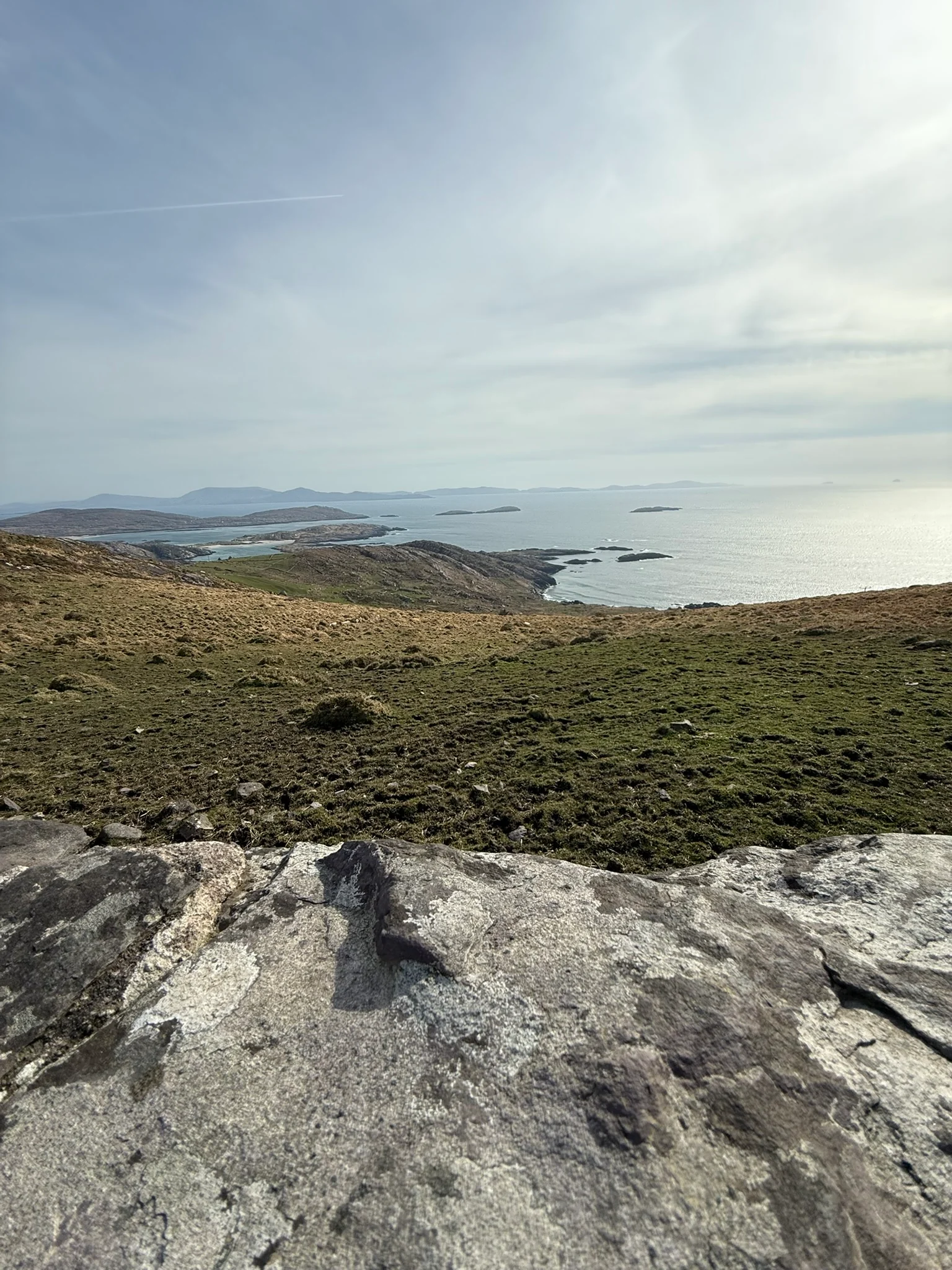 A high coastal overlook on the Ring of Kerry with islands and pale blue water in the distance.